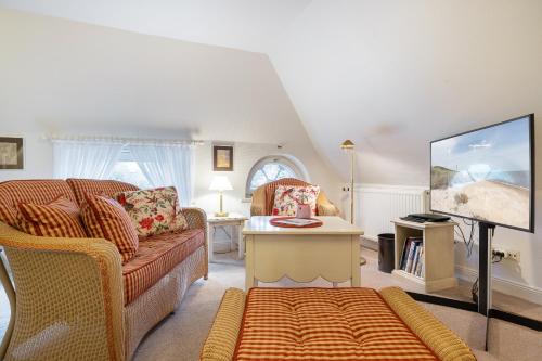 a living room with a couch and a tv at Haus Süderende in Keitum