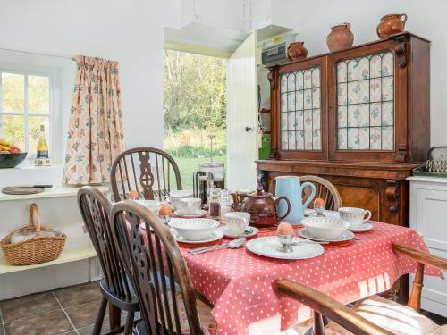 a dining room with a table with a red and white table cloth at Gore Cottage in Powerstock