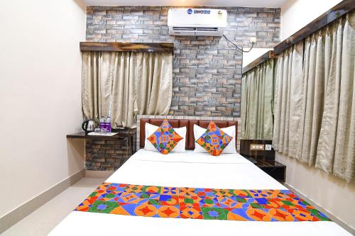 a bedroom with a bed with a colorful comforter at FabHotel Sriya in Durgāpur