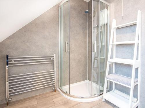 um chuveiro de vidro num quarto com uma escada em Colbheinn Cottage em Brora
