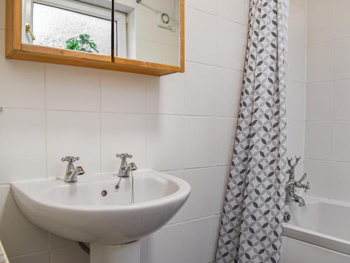 uma casa de banho com um lavatório e um chuveiro em Winsbeer Cottage em Buckland Monachorum