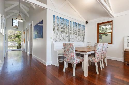 a dining room with a table and chairs at Barefoot on Blueys in Blueys Beach