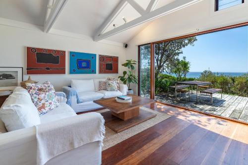 a living room with a couch and a table at Barefoot on Blueys in Blueys Beach