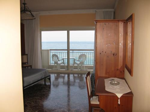 a living room with a table and a view of the ocean at Costa Azzurra in Giardini Naxos