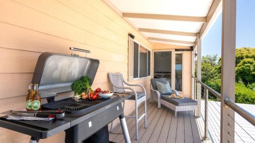 a grill on a balcony with a table with vegetables at Marilyn's in Callala Beach