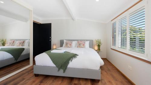 a bedroom with two beds and a large window at Marilyn's in Callala Beach
