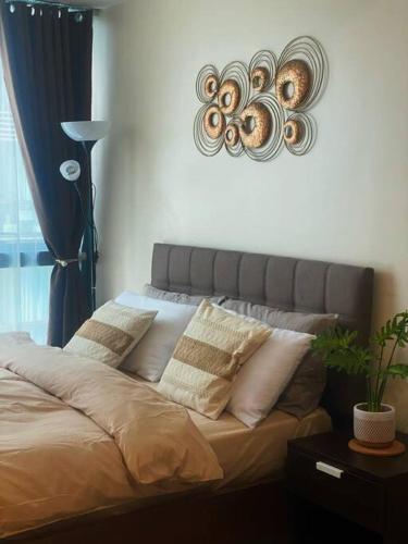 a bedroom with a bed with pillows on it at Uptown Stays+ Free pool access & Building views in Manila