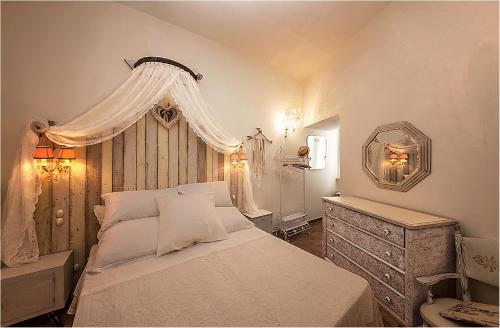 sypialnia z białym łóżkiem, komodą i lustrem w obiekcie Spello House Patio w mieście Spello