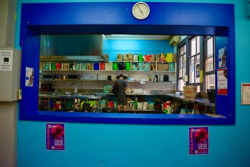 a counter in a store with a clock above it at Maze Backpackers - Sydney in Sydney
