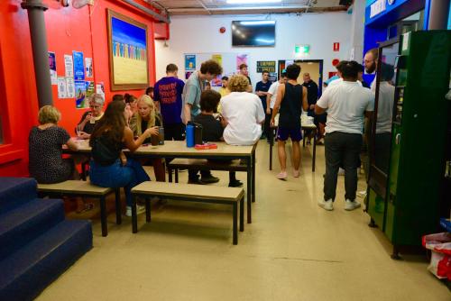 um grupo de pessoas sentadas à mesa numa sala em Maze Backpackers - Sydney em Sydney