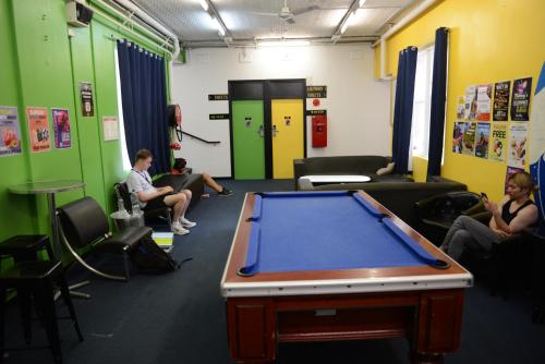 a pool table in a room with people sitting around at Maze Backpackers - Sydney in Sydney