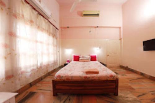 迪馬普爾的住宿－Trinity Villa Dimapur，一间卧室配有一张带红色枕头的床