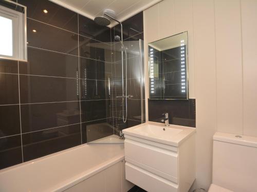 a bathroom with a sink and a toilet and a shower at 2 Bed in Conwy 60292 in Llangelynin