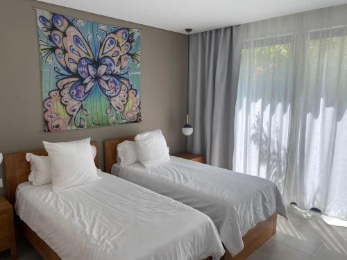 ein Schlafzimmer mit 2 Betten und einem Wandgemälde in der Unterkunft Pomelo 3 in Ruisseau Créole