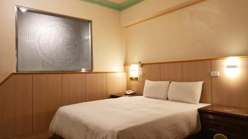 a hotel room with a bed and a window at Longchi Hot-Spring Hotel in Jiaoxi