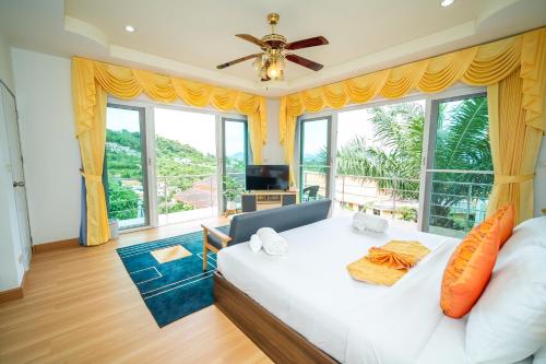 ฺBaan Waru seaview villa في Ban Kata: غرفة نوم بسرير ونافذة كبيرة