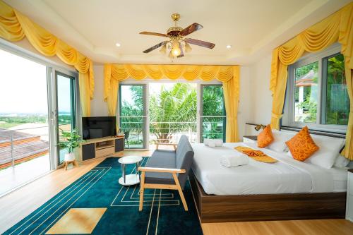 a bedroom with a bed and a large window at ฺBaan Waru seaview villa in Ban Kata