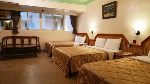 a hotel room with two beds and a chair at Longchi Hot-Spring Hotel in Jiaoxi