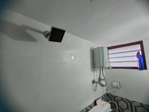 a bathroom with a toilet and a speaker on the wall at My Nest - Best Homestay for Peaceful Stay with Comfort in Bhuj