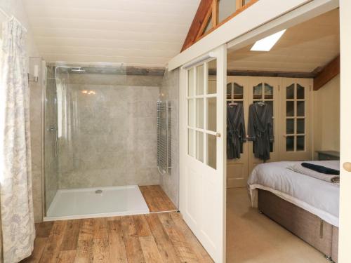 a bathroom with a shower and a bed and a tub at The Coach House in Pembroke