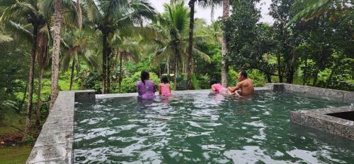 a group of people sitting in a swimming pool at Elnora's Farm in Lucban