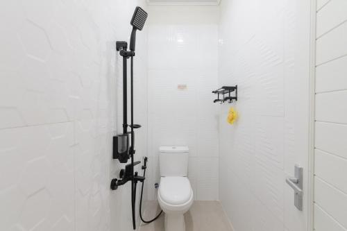 ein weißes Bad mit einem WC und einer Dusche in der Unterkunft Urbanview Hotel Binwa Syariah Bandar Lampung in Hajimana