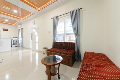 ein Wohnzimmer mit einem Sofa und einem Tisch in der Unterkunft Urbanview Hotel Binwa Syariah Bandar Lampung in Hajimana