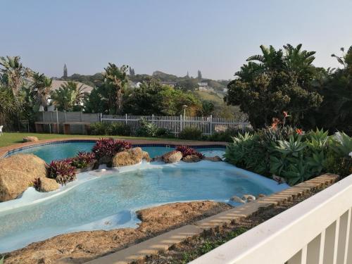 a swimming pool with rocks in a yard at Glenmore Sands Beach Resort in Port Edward