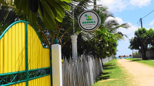 a sign on a fence next to a yellow fence at Regina Beach Bungalow in Trincomalee