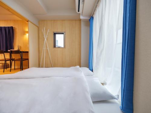 1 Schlafzimmer mit 2 Betten und einem Fenster in der Unterkunft Dc桜の苑403和式双人房间 in Osaka