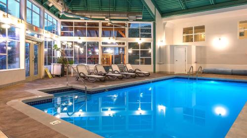 a swimming pool with chairs in a building at Gibsons Garden Hotel in Gibsons