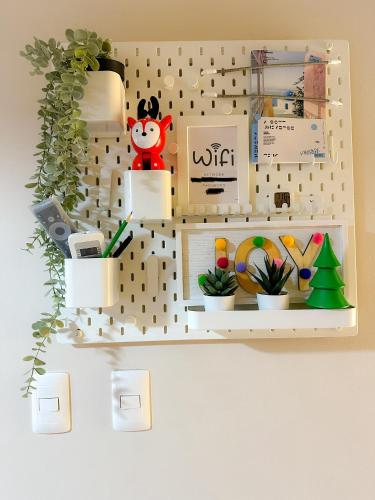 a toy shelf with plants and toys on it at 1BR BGC Uptown Modern Condo Netflix 200Mb Wifi in Manila
