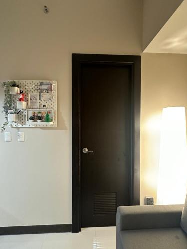 a black door in a room with a couch at 1BR BGC Uptown Modern Condo Netflix 200Mb Wifi in Manila