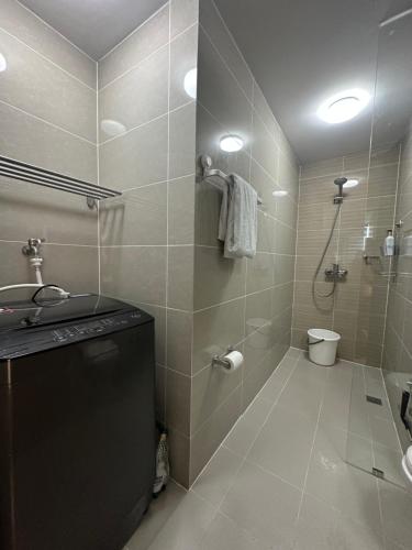 a bathroom with a shower and a sink and a toilet at 1BR BGC Uptown Modern Condo Netflix 200Mb Wifi in Manila