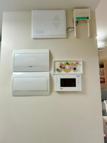 a kitchen with white cabinets and a microwave on a wall at 1BR BGC Uptown Modern Condo Netflix 200Mb Wifi in Manila