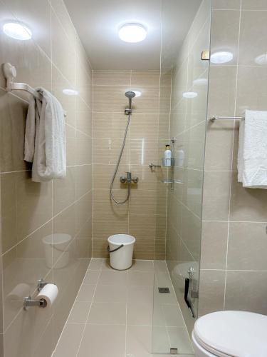 a bathroom with a shower and a toilet at 1BR BGC Uptown Modern Condo Netflix 200Mb Wifi in Manila