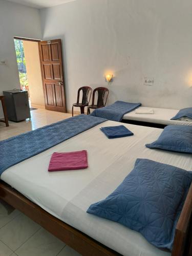 4 camas en una habitación con sillas y una puerta en VILLA SOL BEACH RESORT en Baga