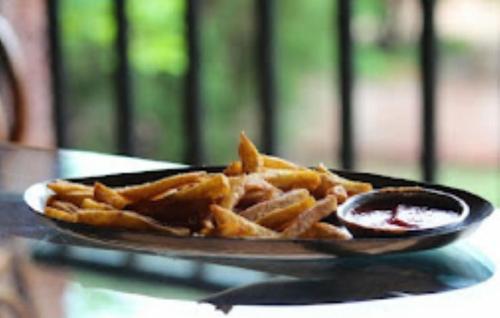 un plato de papas fritas en una mesa en Heritage Resort , Kolhapur, en Kolhapur