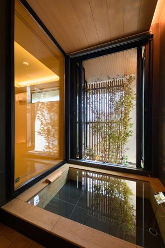 a bathtub in a room with a large window at HAKO REIRO 箱・玲瓏 in Hakone