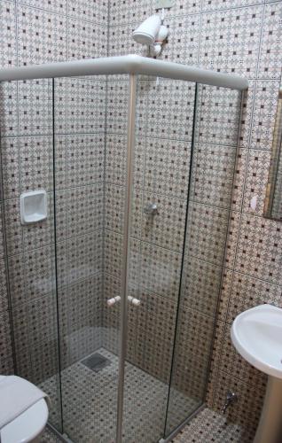 a shower stall with a toilet and a sink at Hotel Santa Rita in Indaiatuba