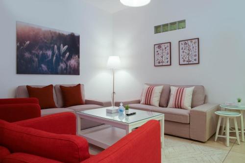 a living room with red chairs and a couch at Toledo Amman Hotel in Amman