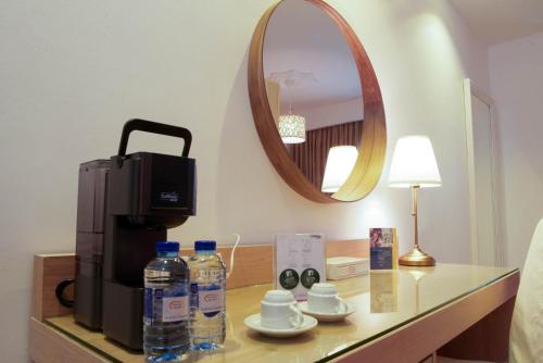 a coffee maker and water bottles on a table in a hotel room at Toledo Amman Hotel in Amman