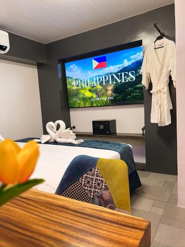 a hotel room with a tv and a bed at CLOCKWORKORANGE Luxury Suites 4-Minutes Away To Airport in Mactan
