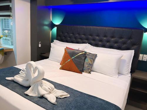 a bedroom with a bed with a swan towel at CLOCKWORKORANGE Luxury Suites 4-Minutes Away To Airport in Mactan