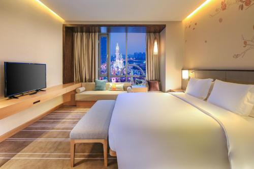 a hotel room with a large bed and a television at Hilton Garden Inn Ningbo in Ningbo