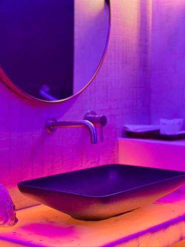 a bathroom with a black sink and a mirror at CLOCKWORKORANGE Luxury Suites 4-Minutes Away To Airport in Mactan