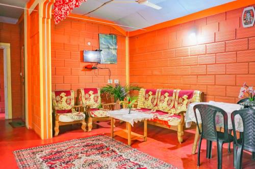 ein Raum mit einem Tisch und Stühlen und einer Wand in der Unterkunft Eshwari Cottage in Madikeri