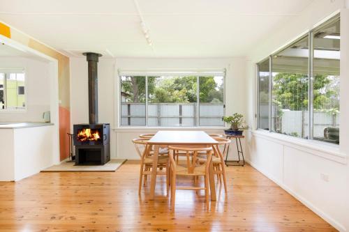 a dining room with a table and a fireplace at Jack's Culburra - Absolute Waterfront with Fireplace in Culburra Beach