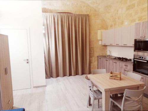a kitchen with a table and chairs in a room at Albachiara suite in Trani