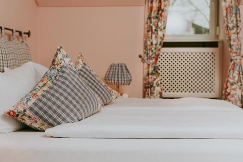 a bedroom with a bed with pillows and a window at Hotel Drei Quellen Therme in Bad Griesbach